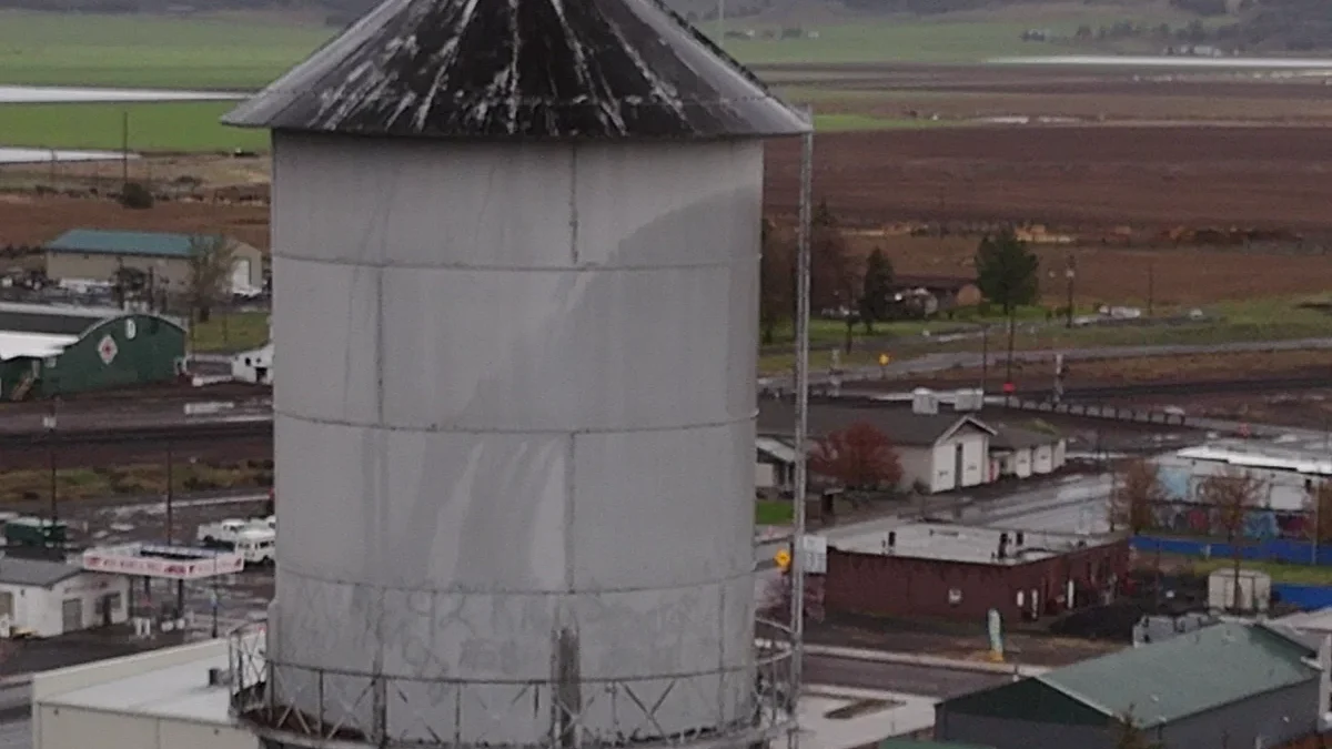 Dorris water tower above homes with farmland beyond