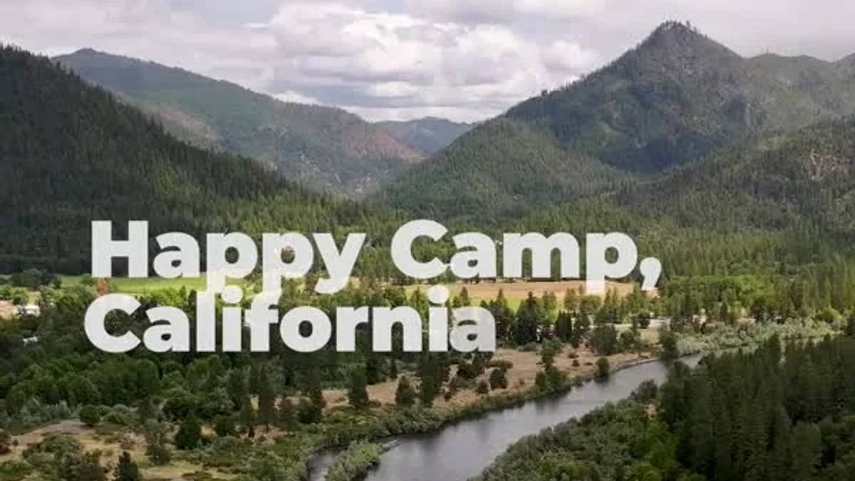 The Klamath River curves between forested hills below the film’s Happy Camp title.