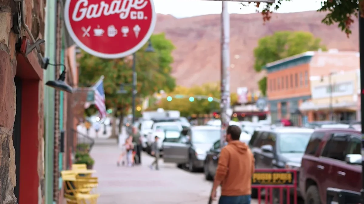 Moab Made sign, Moab Garage Co. sign and people on a downtown sidewalk
