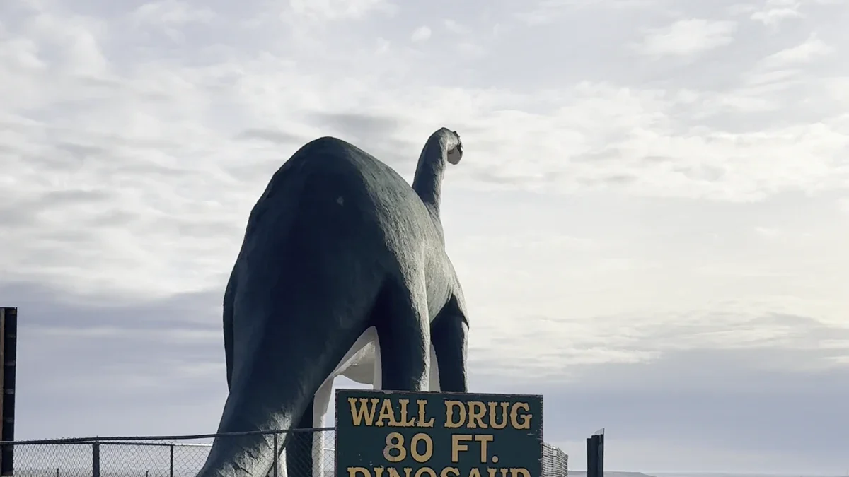 Large Wall Drug dinosaur and its roadside sign