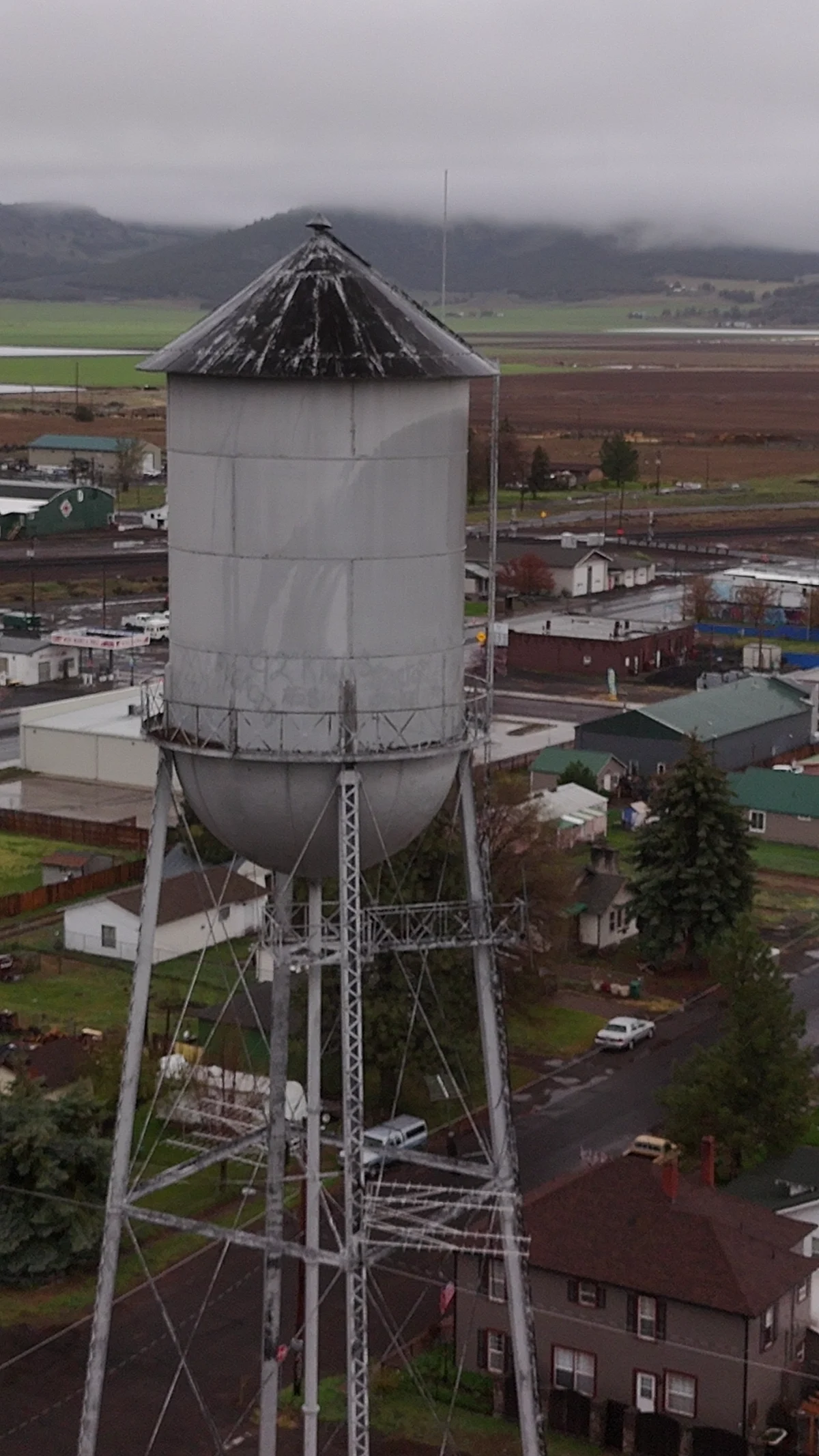 Dorris water tower above homes with farmland beyond