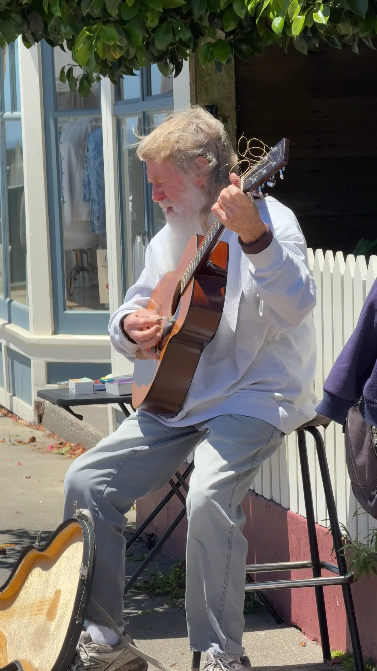 A guitarist plays outside a Mendocino storefront.