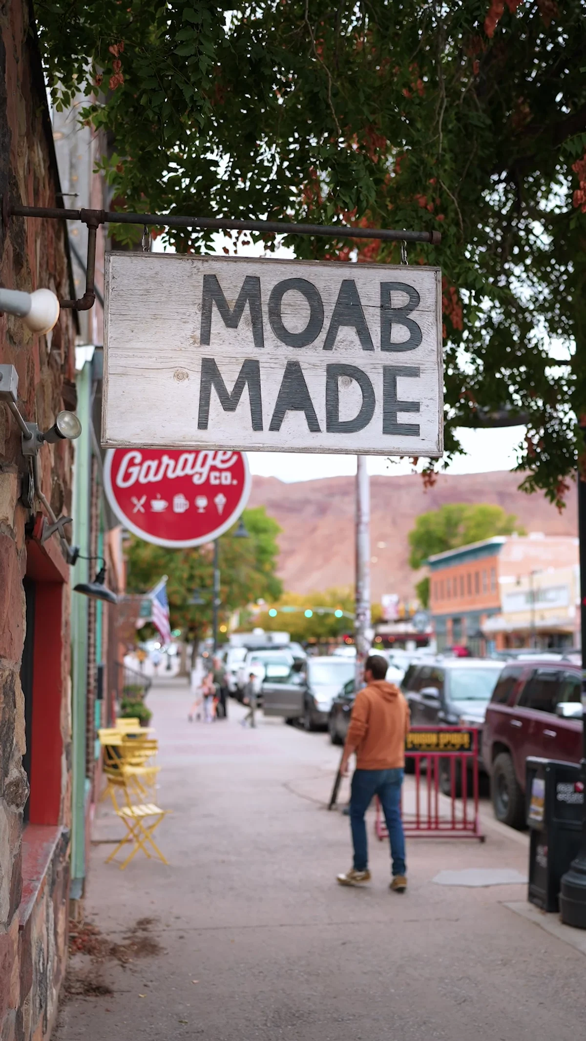 Moab Made sign, Moab Garage Co. sign and people on a downtown sidewalk