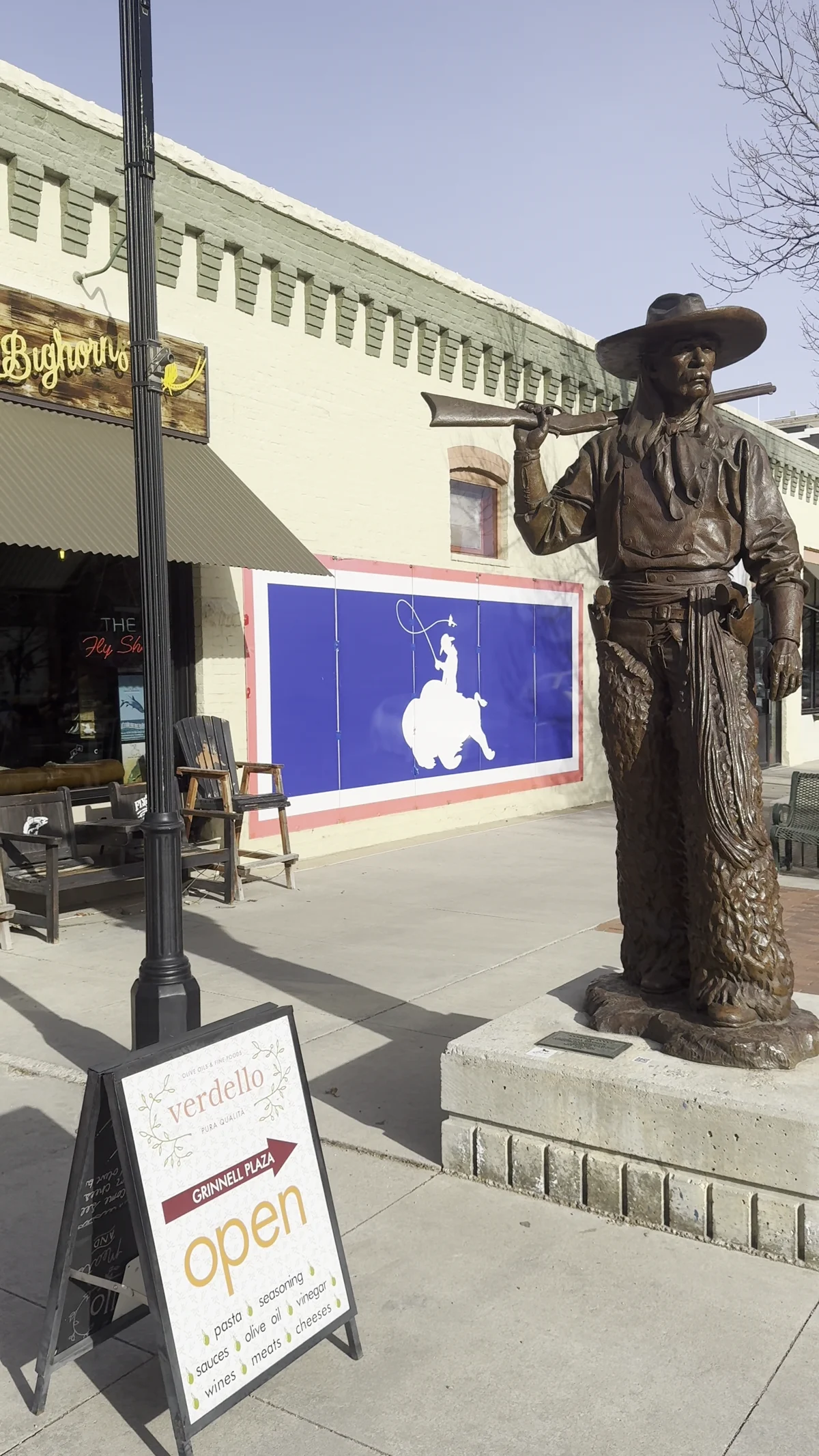 Cowboy sculpture beside a Sheridan storefront