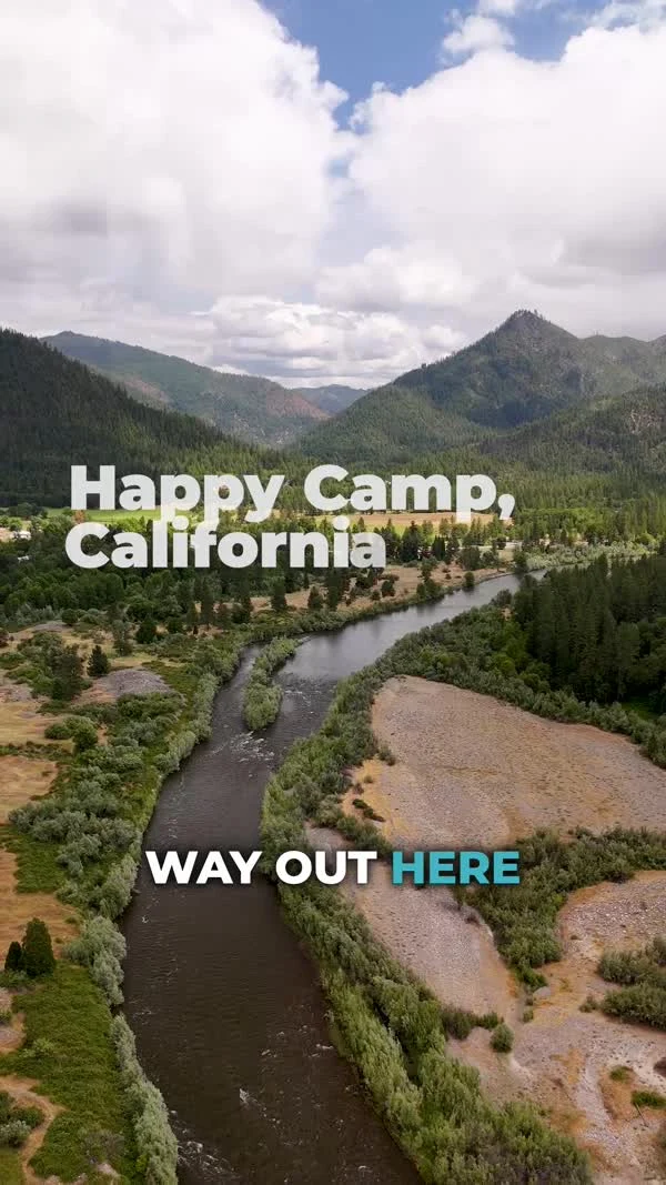 The Klamath River curves between forested hills below the film’s Happy Camp title.