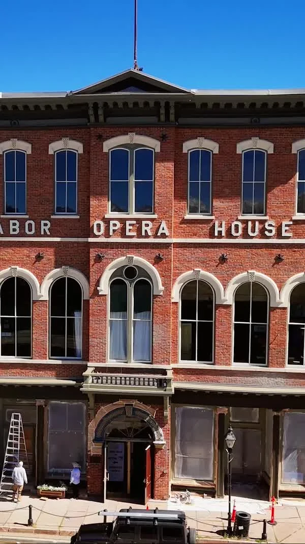 The brick Tabor Opera House facade and tall blue windows face the street.