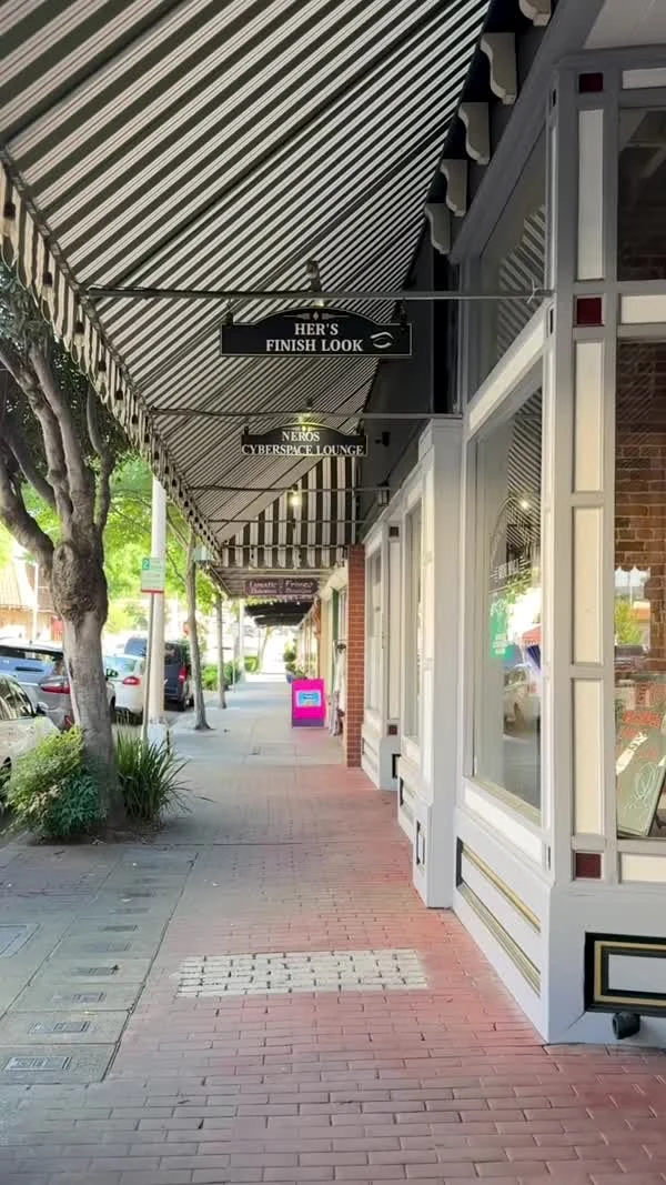 Trees and striped awnings shade downtown Oroville storefronts.