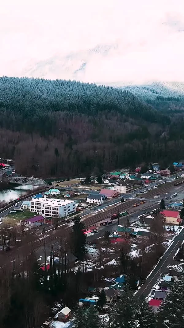 Snow-dusted Skykomish and its railway sit beneath forested mountains.