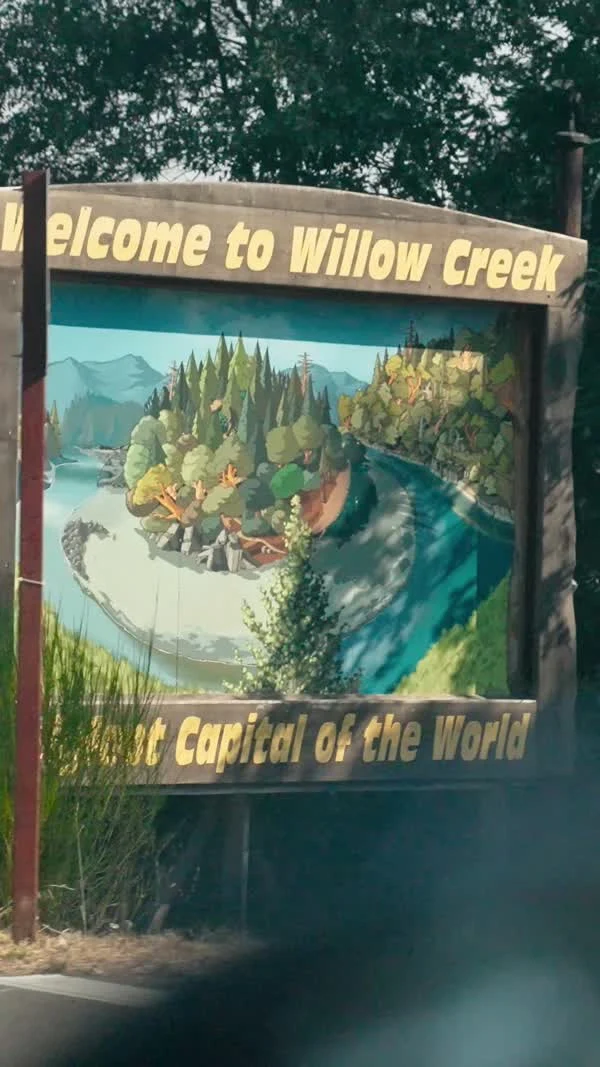 A painted roadside sign welcomes visitors to Willow Creek, Bigfoot Capital of the World.