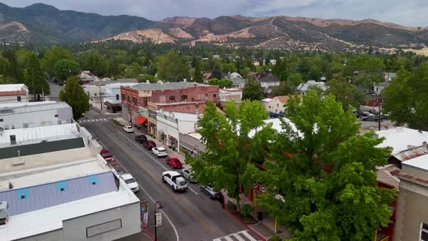 An aerial view shows Yreka streets and rooftops against dry hills.